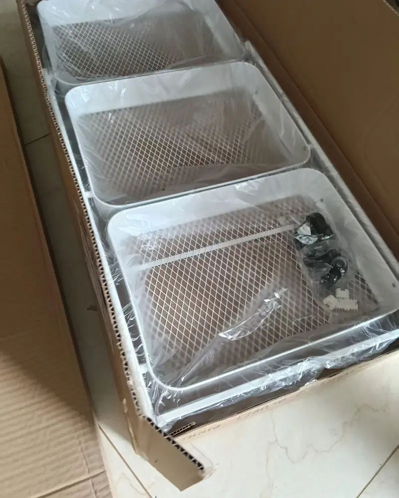 White metal baskets in a carton, wrapped in plastic