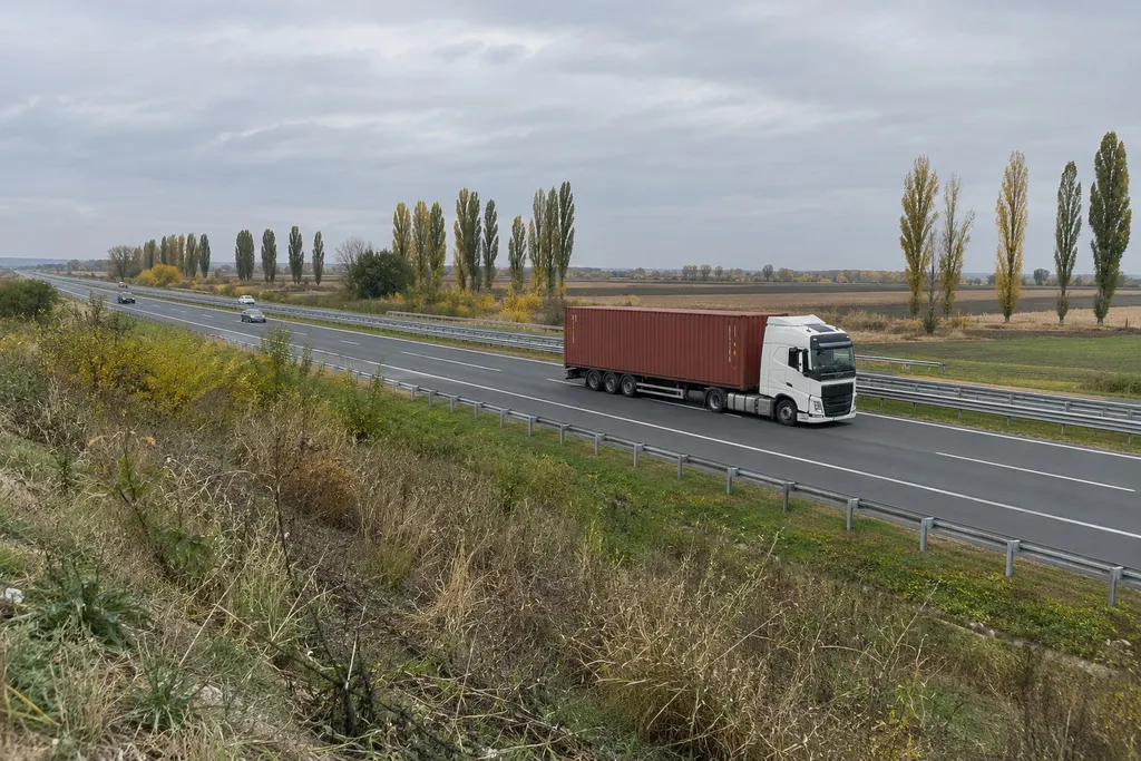 Truck with a container on a motorway across the flat plain near Belgrade in autumn